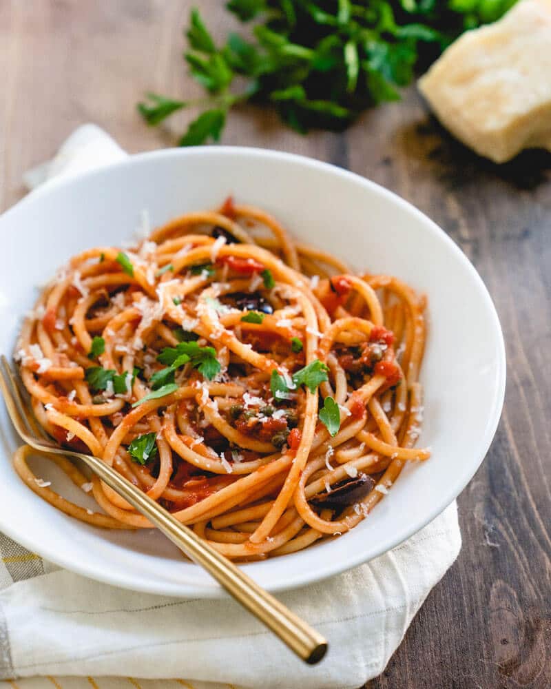 homemade pasta puttanesca in white bowl