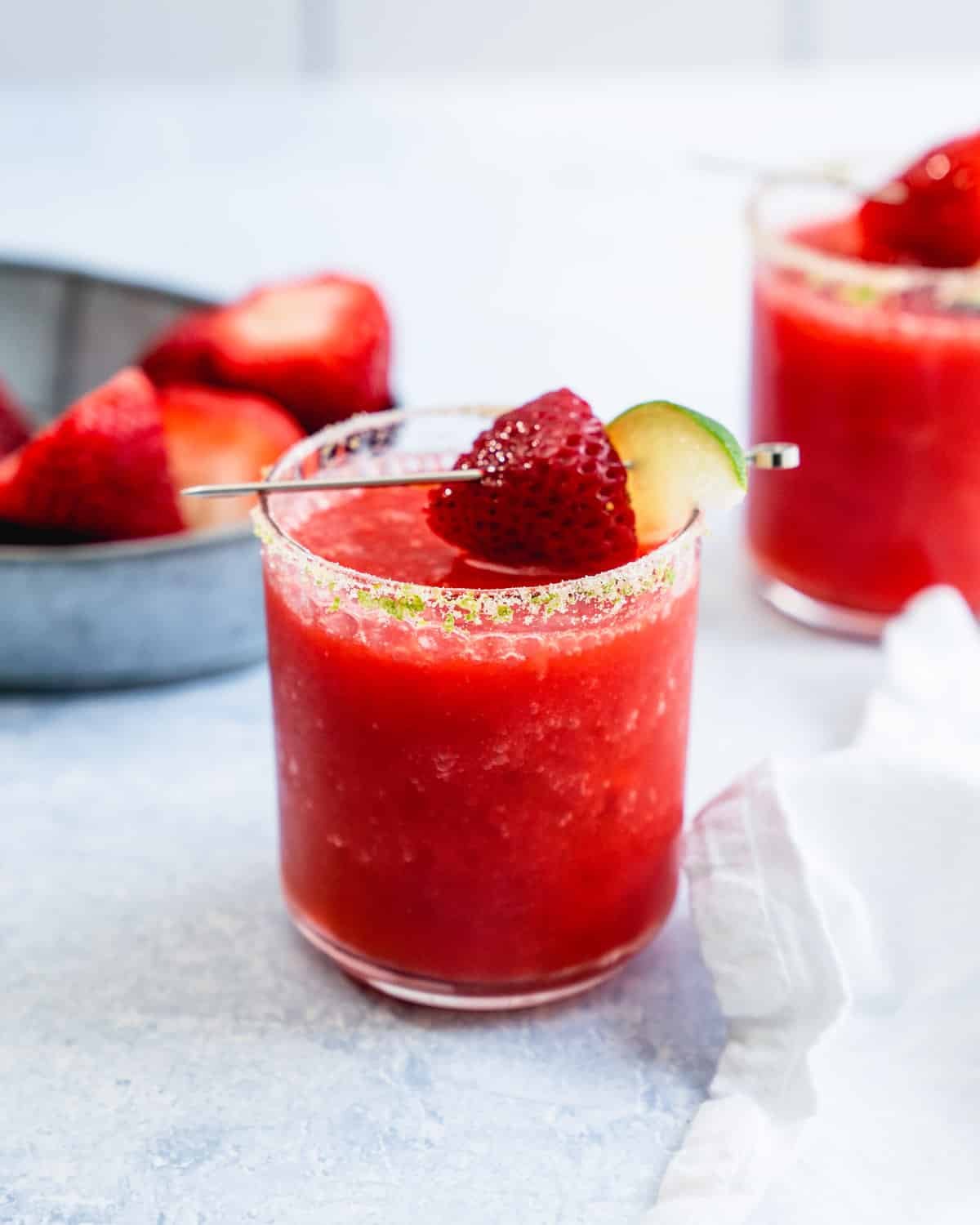 Strawberry Margarita in rocks glass with salt rim and strawberry garnish