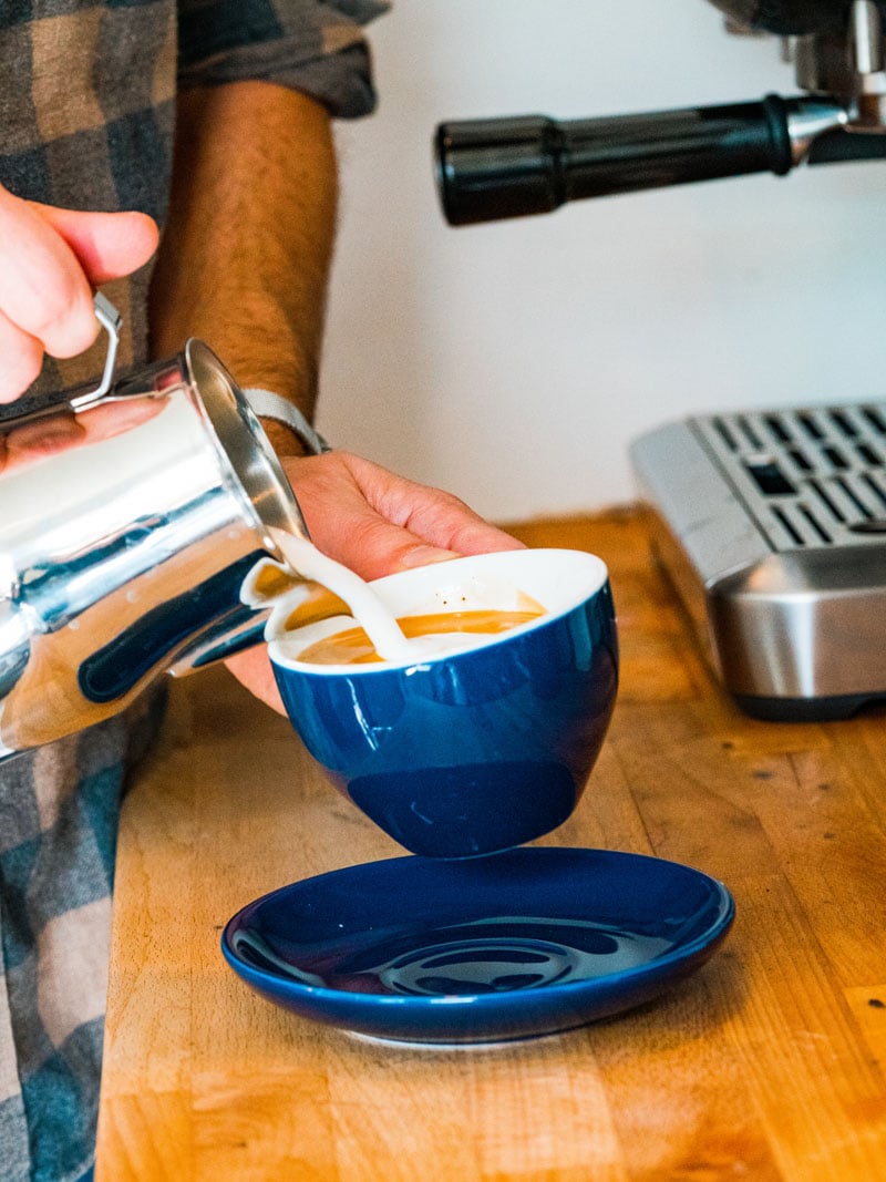 Pouring the milk into espresso in a latte