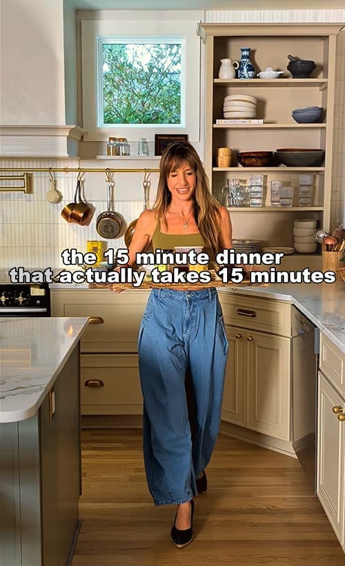Sonja carrying a tray of dinner ingredients through the kitchen